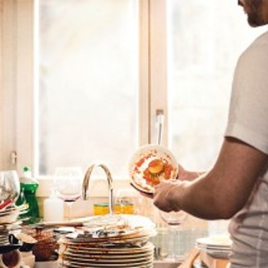 Mies tiskaamassa likaisia astioita