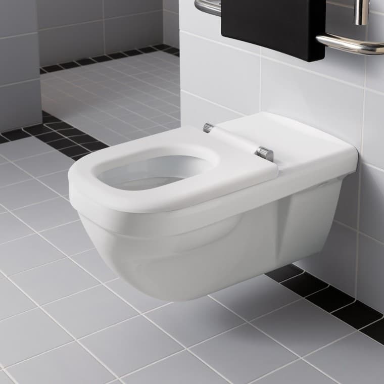 Renova Comfort -malliston seinä-wc-istuimien pidennetty ulottuma, joka helpottaa istuimelle siirtymistä rullatuolista. Renova Comfort -malliston seinä-wc-istuimien pidennetty ulottuma, joka helpottaa istuimelle siirtymistä rullatuolista.
